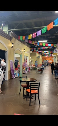 the inside of a shopping mall with tables and chairs